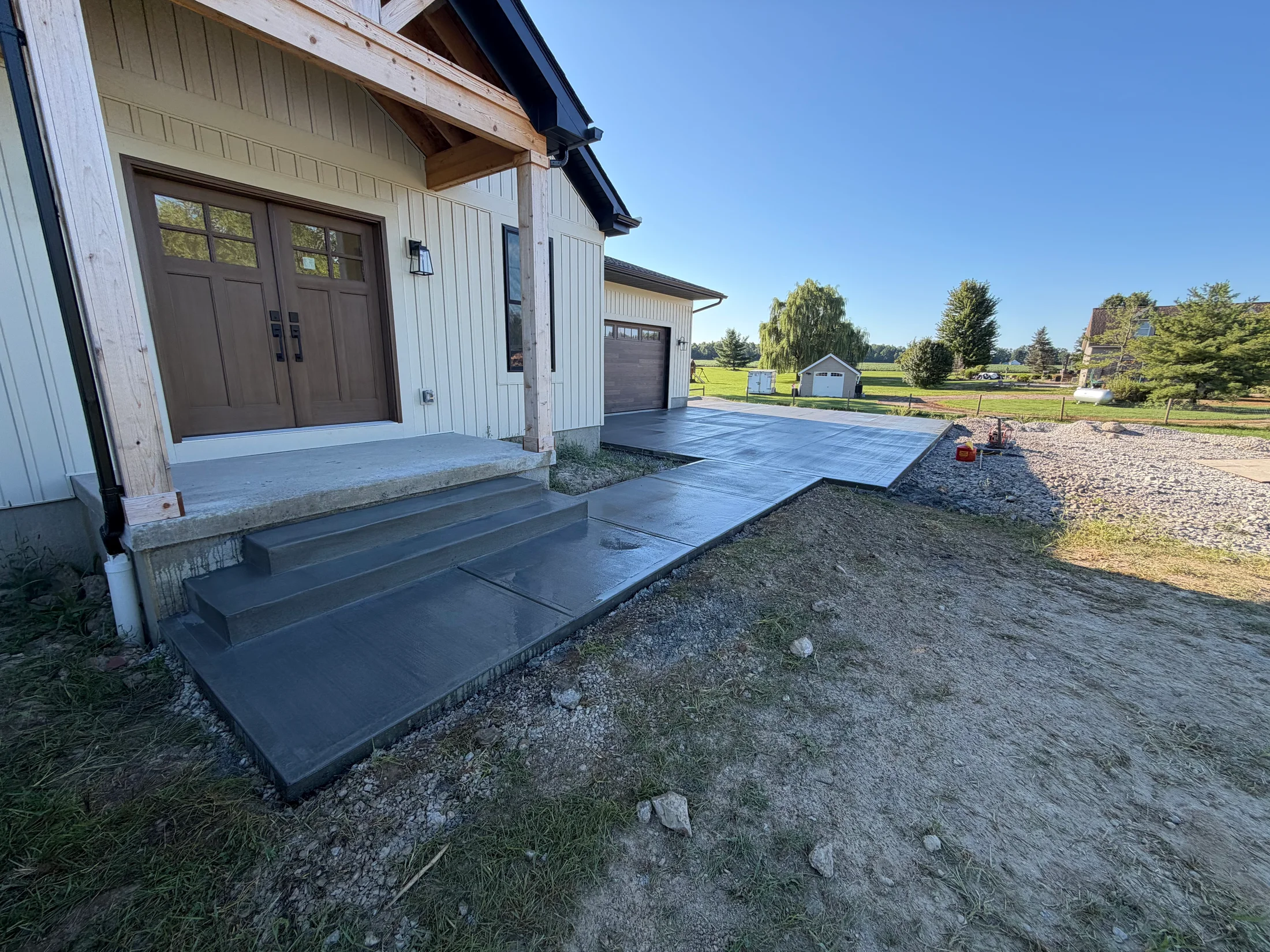 Concrete entry steps and walkway connecting the front porch to the garage apron.