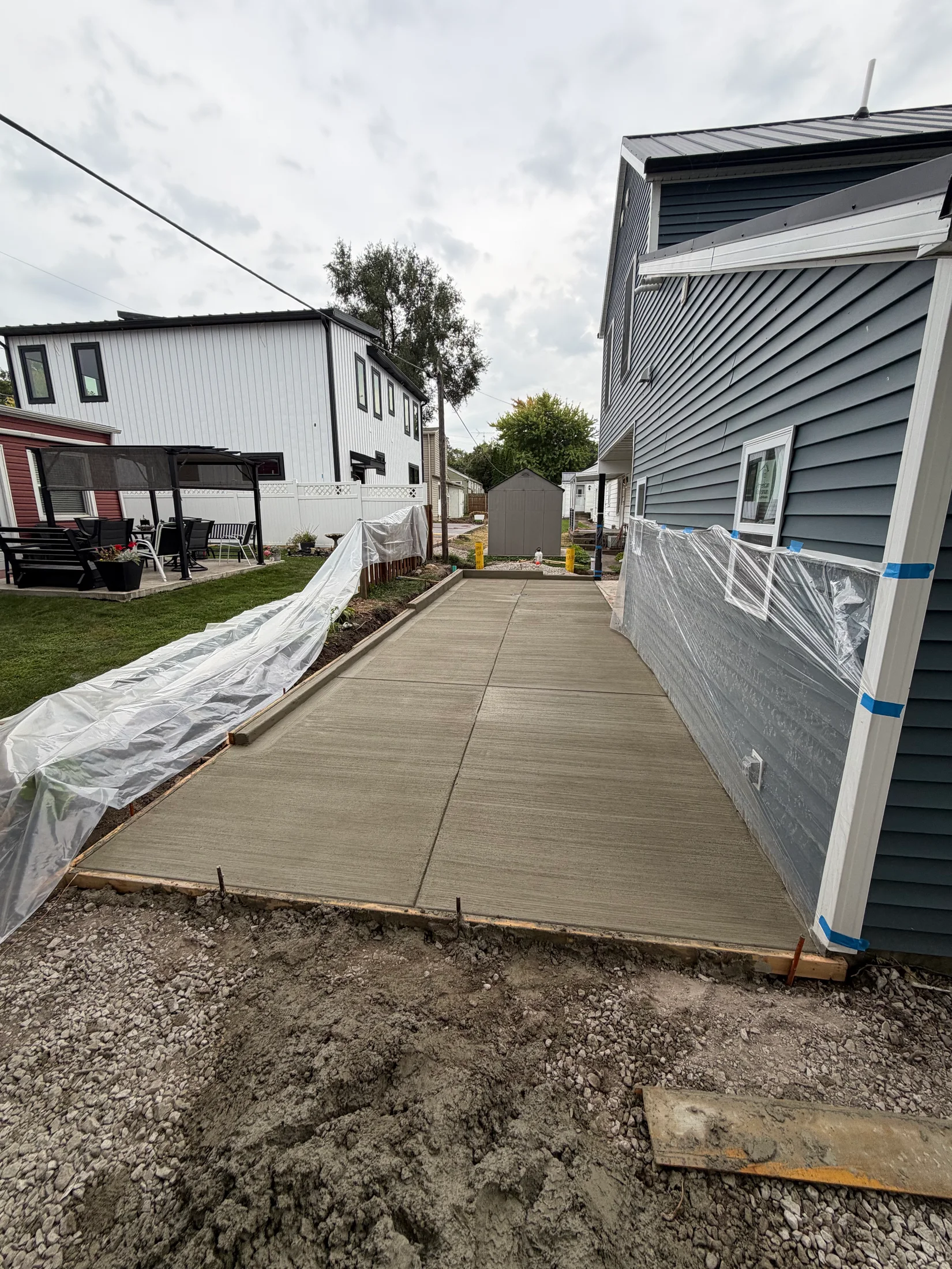 Broom-finished concrete slab alongside the house.